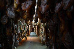 Pasillo de secadero con jamones ibéricos DOP Los Pedroches curándose colgados